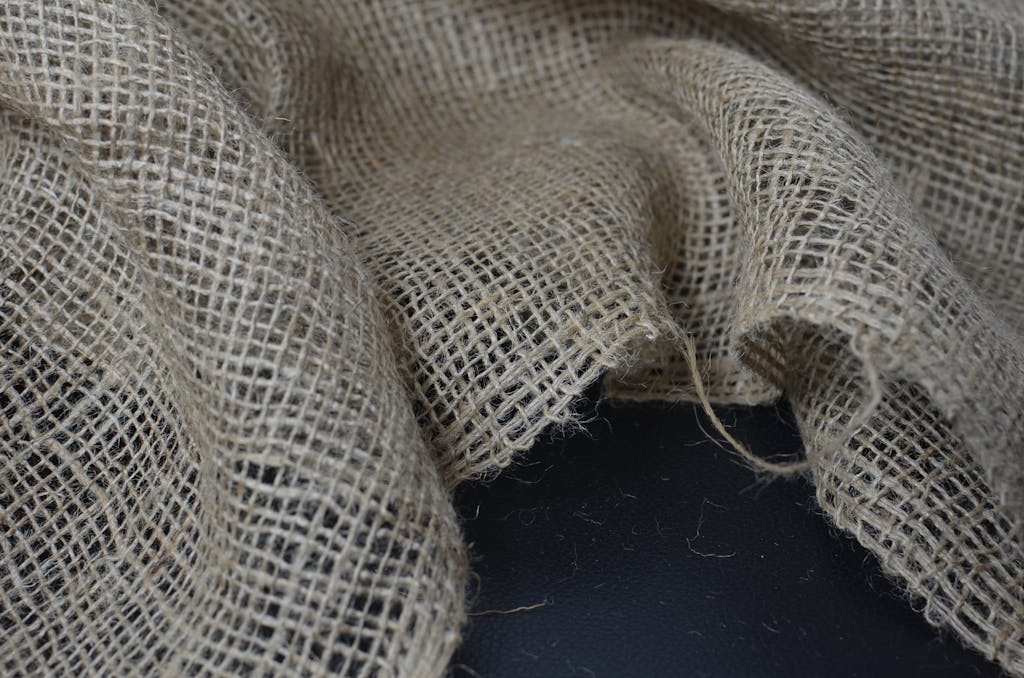 Overhead view closeup of eco burlap with tiny holes and rough texture with creased surface