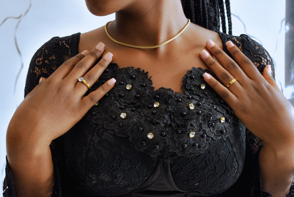 A woman with black lace dress and gold jewelry