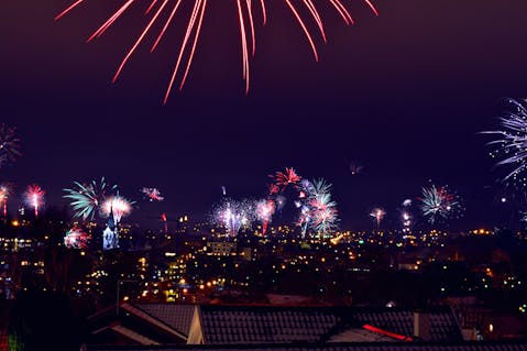 Vibrant fireworks light up the night sky over a city. Perfect for celebrations or festive events.