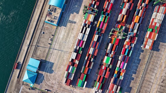 Top view of colorful shipping containers at a bustling port in Jakarta, Indonesia.