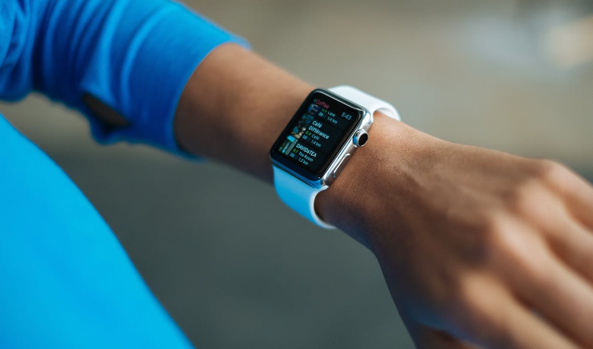 Focus on a smartwatch worn on an adult's wrist, showcasing its digital display.