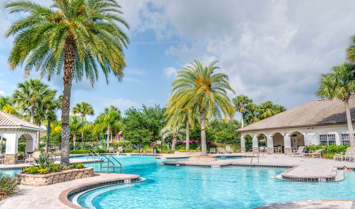 Idyllic tropical resort featuring palm trees, tranquil poolside setting, and relaxing vacation vibes.